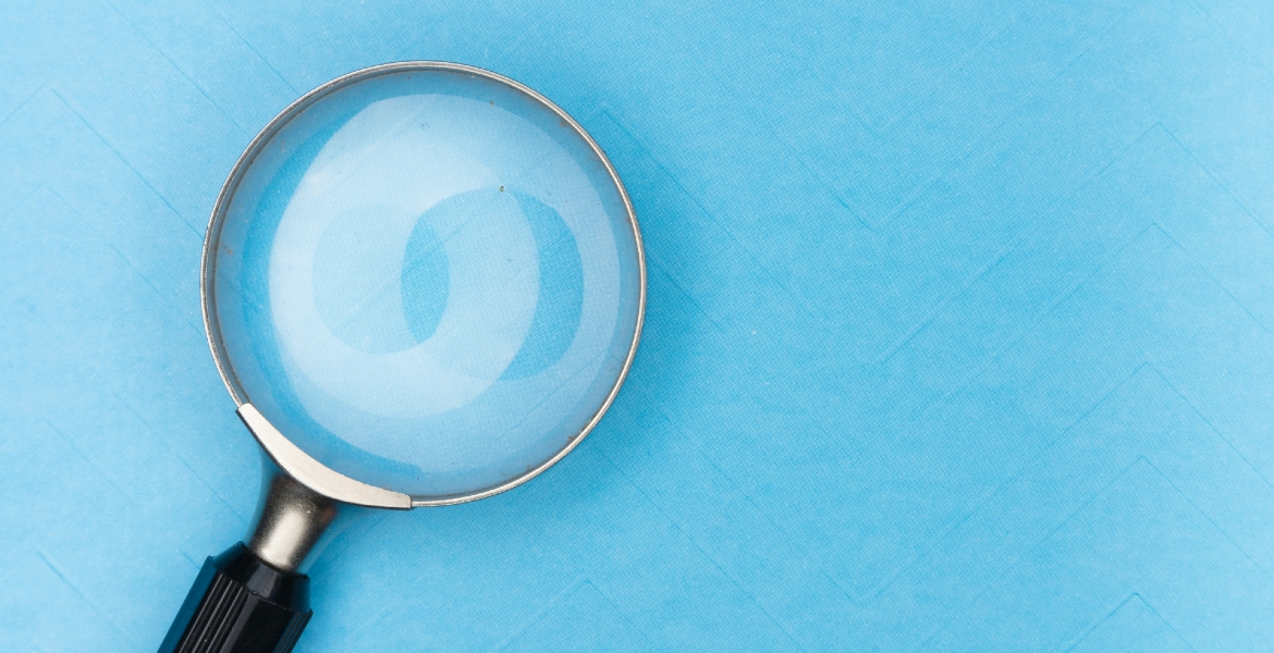Photograph of a magnifying glass on a blue background