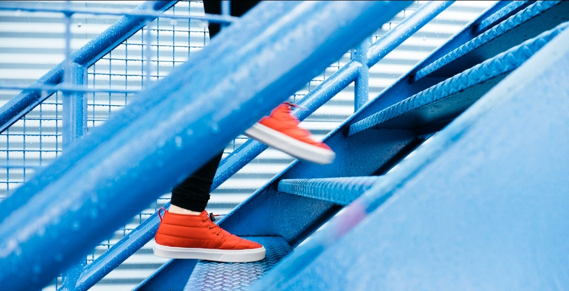 Photograph of a woman wearing red sneakers walking up stairs