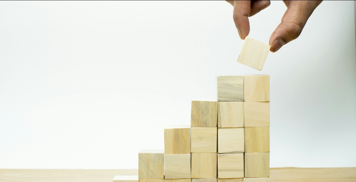 Photograph of a hand stacking wooden blocks