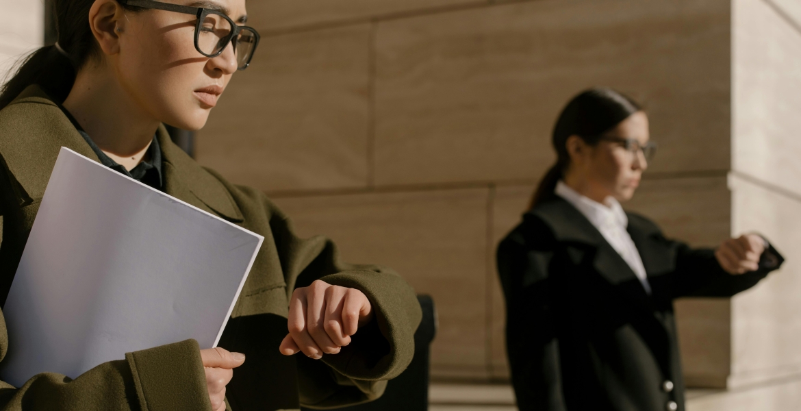 Female executive employees waiting while looking at their watches