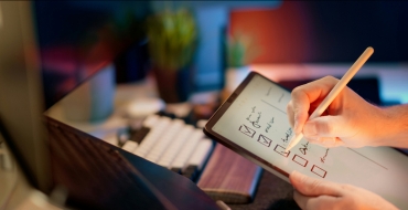 Photograph of a man writing on a tablet