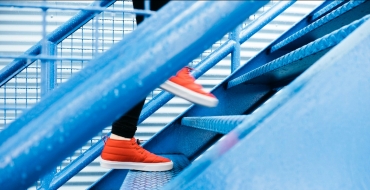Photograph of a woman wearing red sneakers walking up stairs